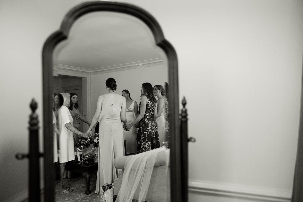 Officiant leads a women's prayer with the bride and her family before the wedding ceremony.