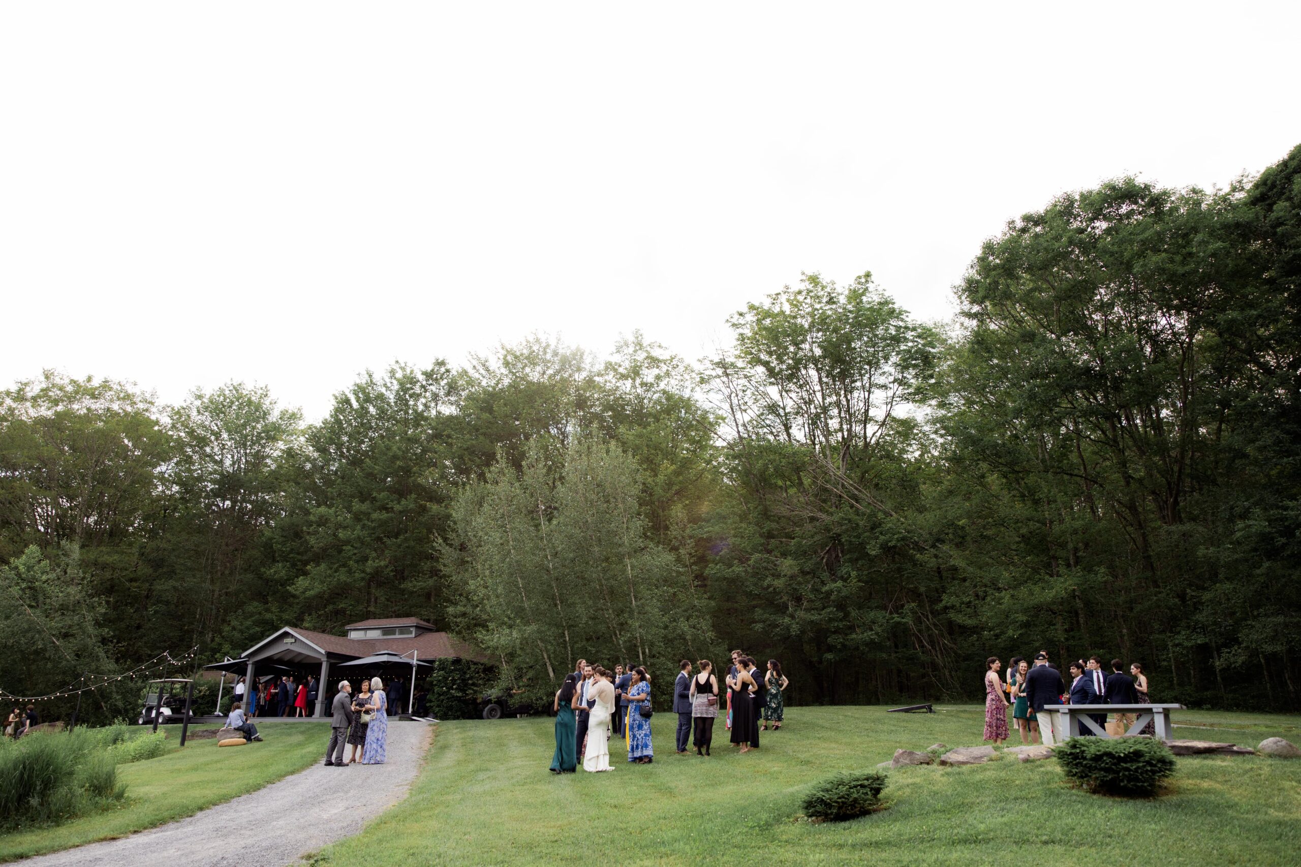 Guests mingle on the lawn at a barn wedding venue in upstate NY. 