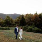 Bride and groom hold hands while walking through nature during their elopement in Upstate New York.