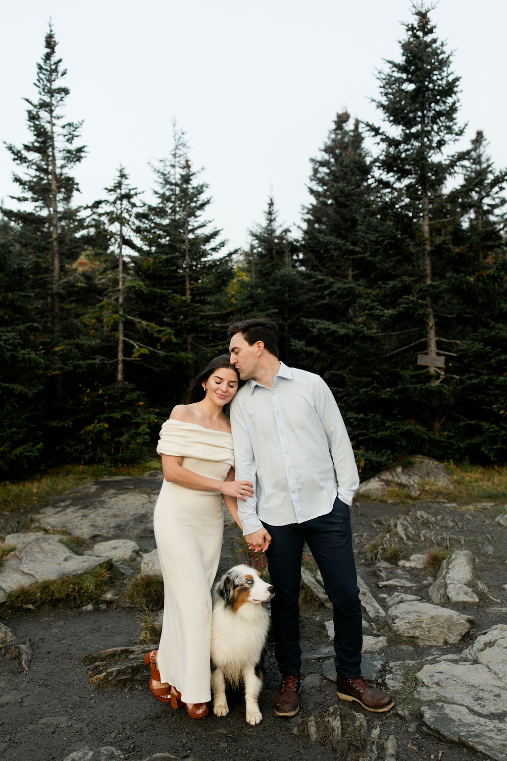 Man kisses woman on her hair during their engagement session in The Whites mountains.