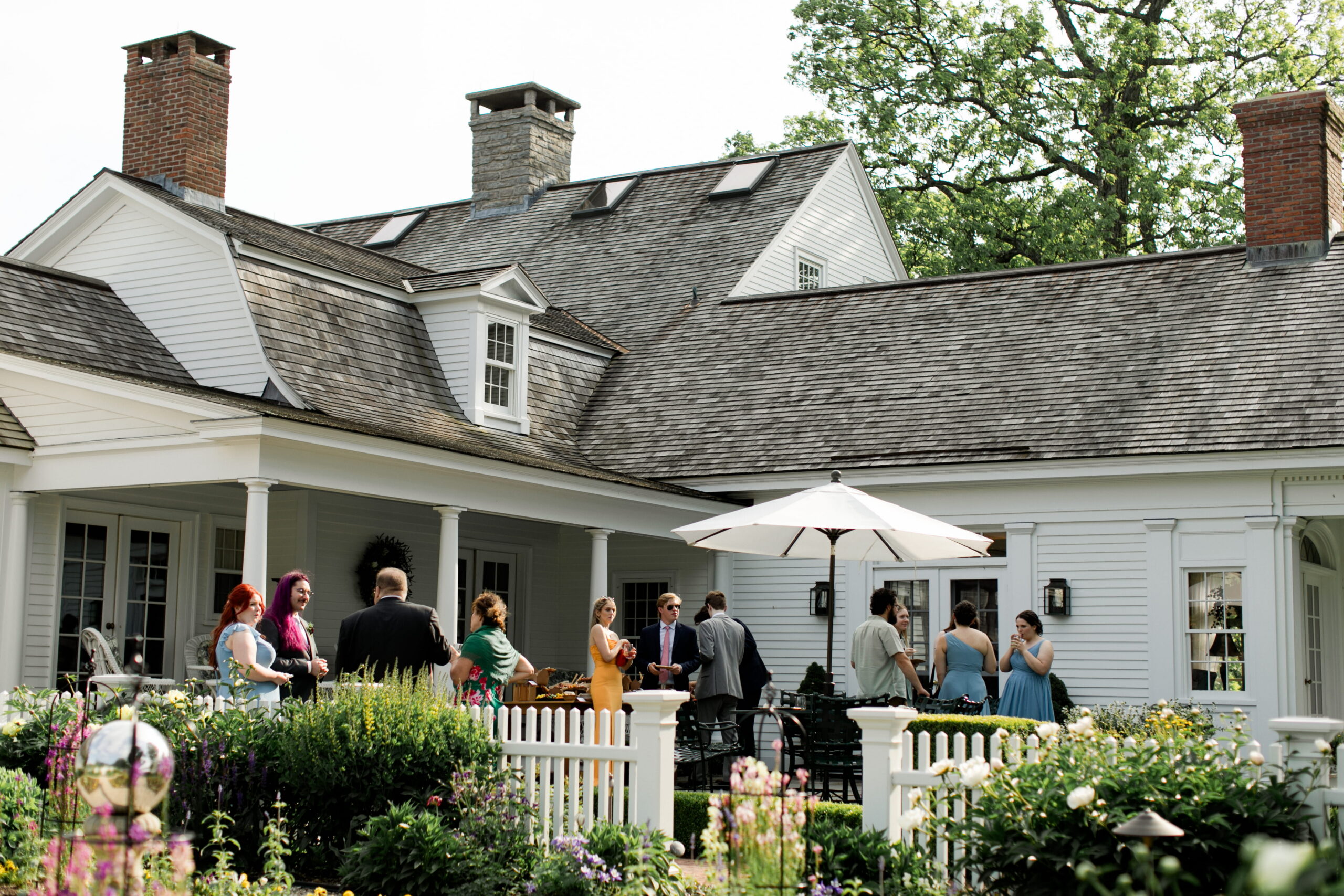 Guests mingle on an outdoor terrace during cocktail hour at a small wedding in Connecticut.