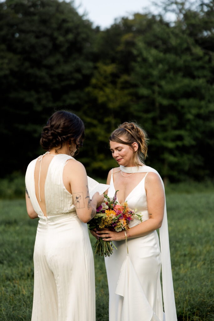 Bride gets emotional while hearing vows from her bride during their New England elopement.